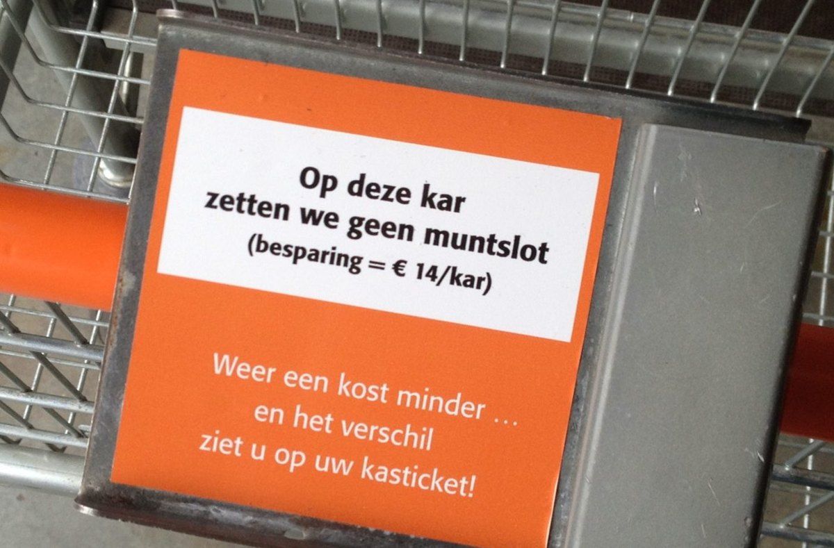 A sign on a Colruyt shopping cart explaining that the cart has no coin lock