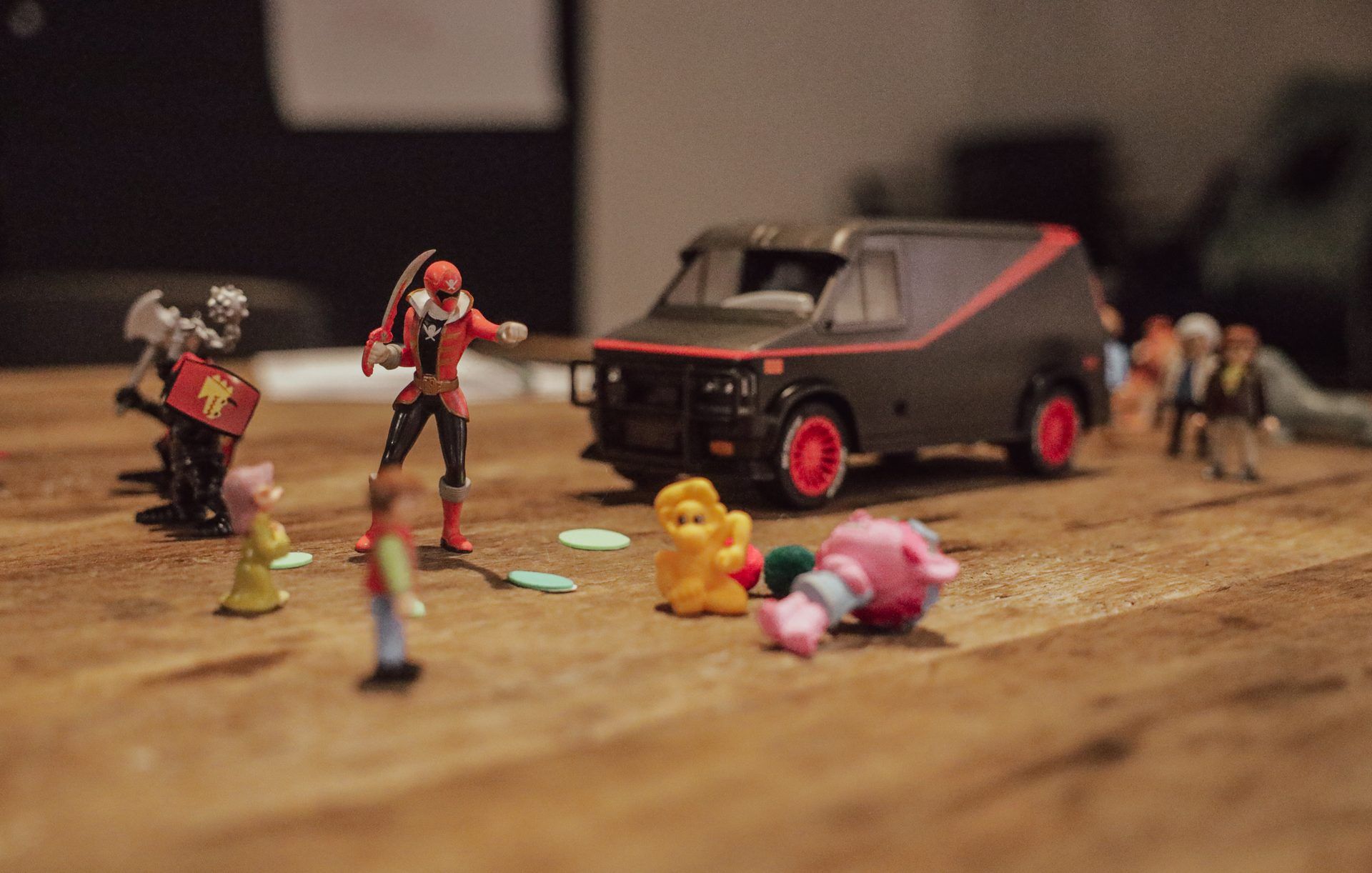 Toy figurines lined up on a wooden workshop table