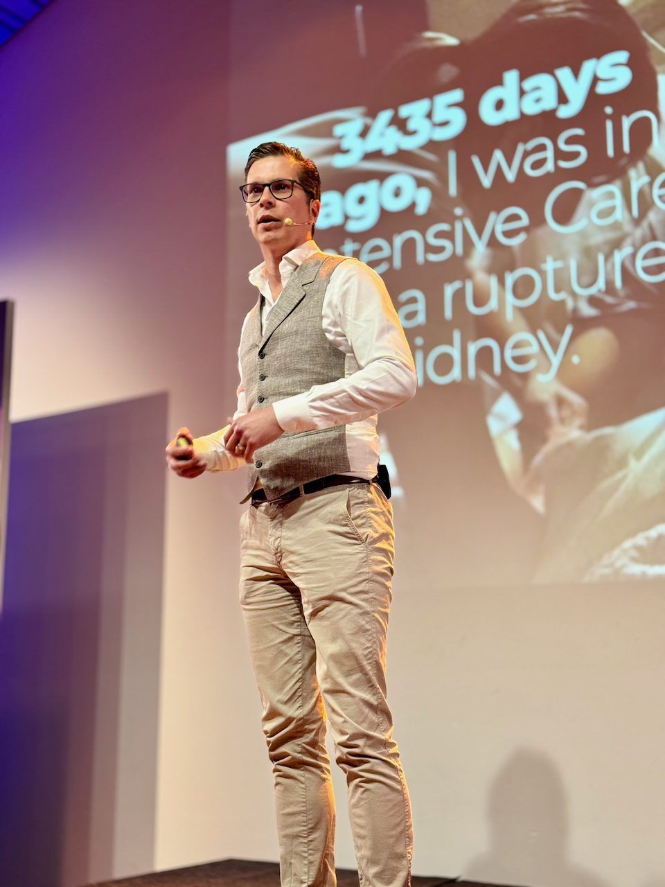 Polle on stage in front of a slide about the day he ended up in intensive care
