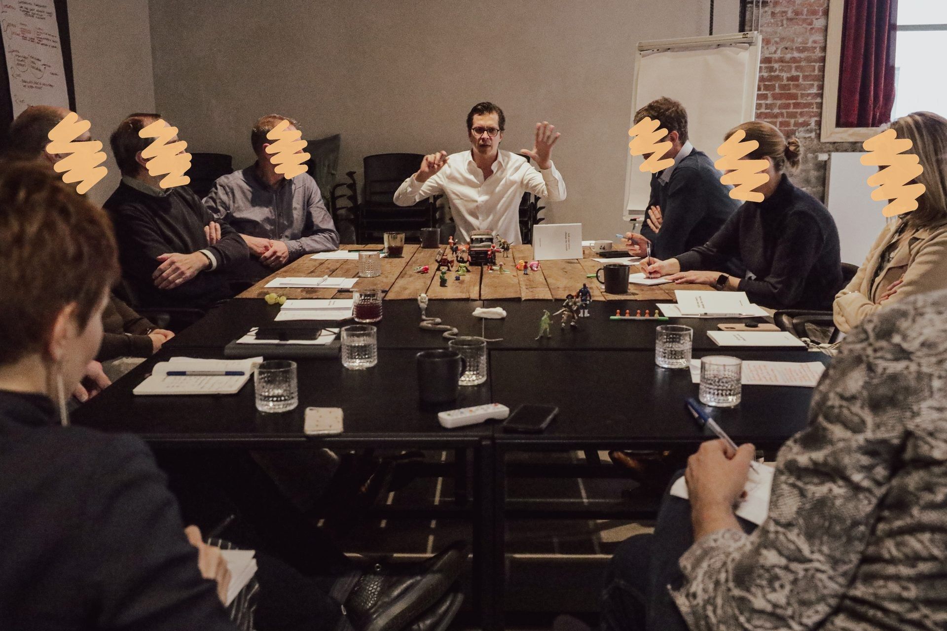 Polle at a workshop table with a leadership team, figurines and notes on the table